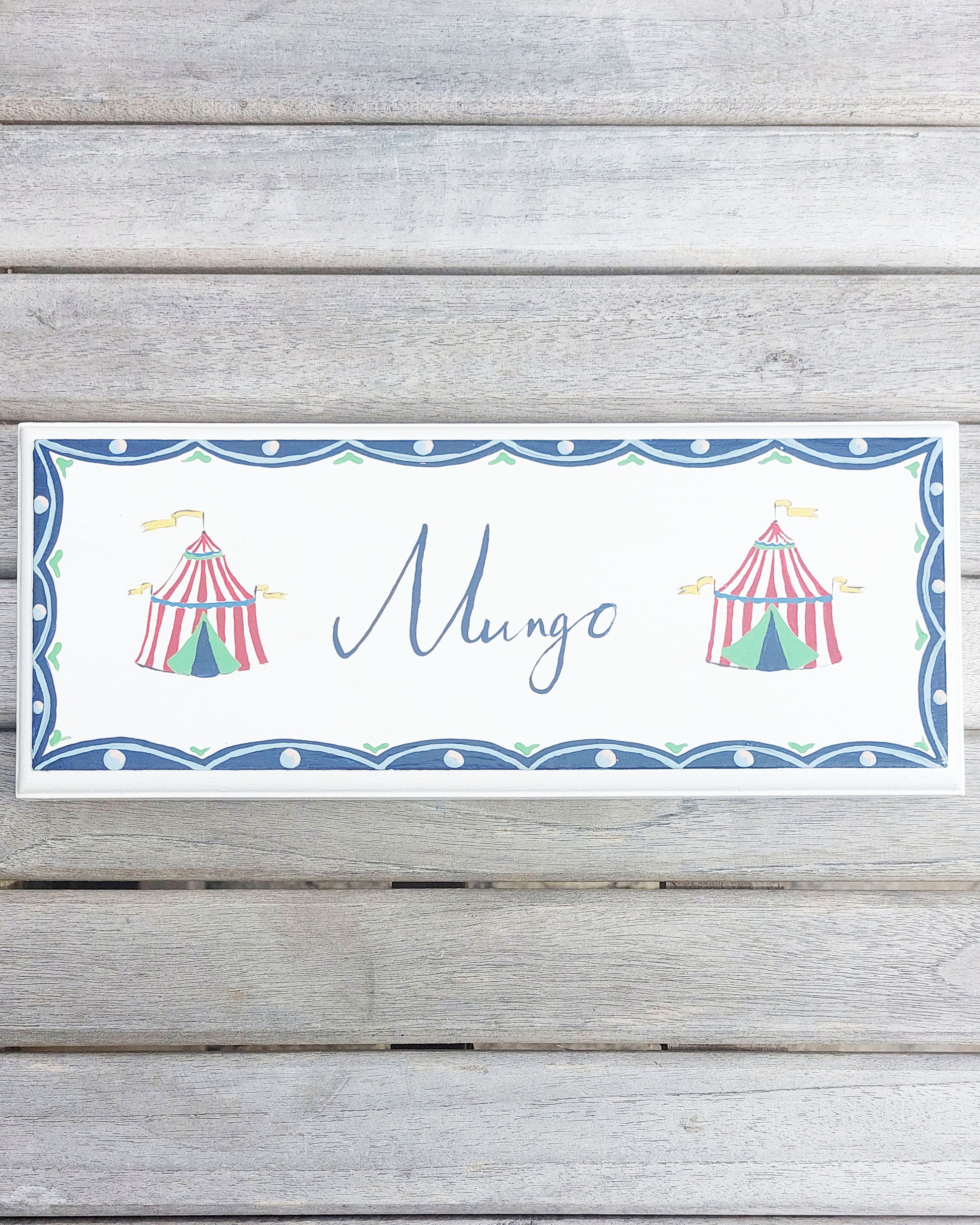 Nursery door sign personalised with the name 'Mungo', featuring Circus big tops and a decorative blue scallop border, perfect for baby room decor.