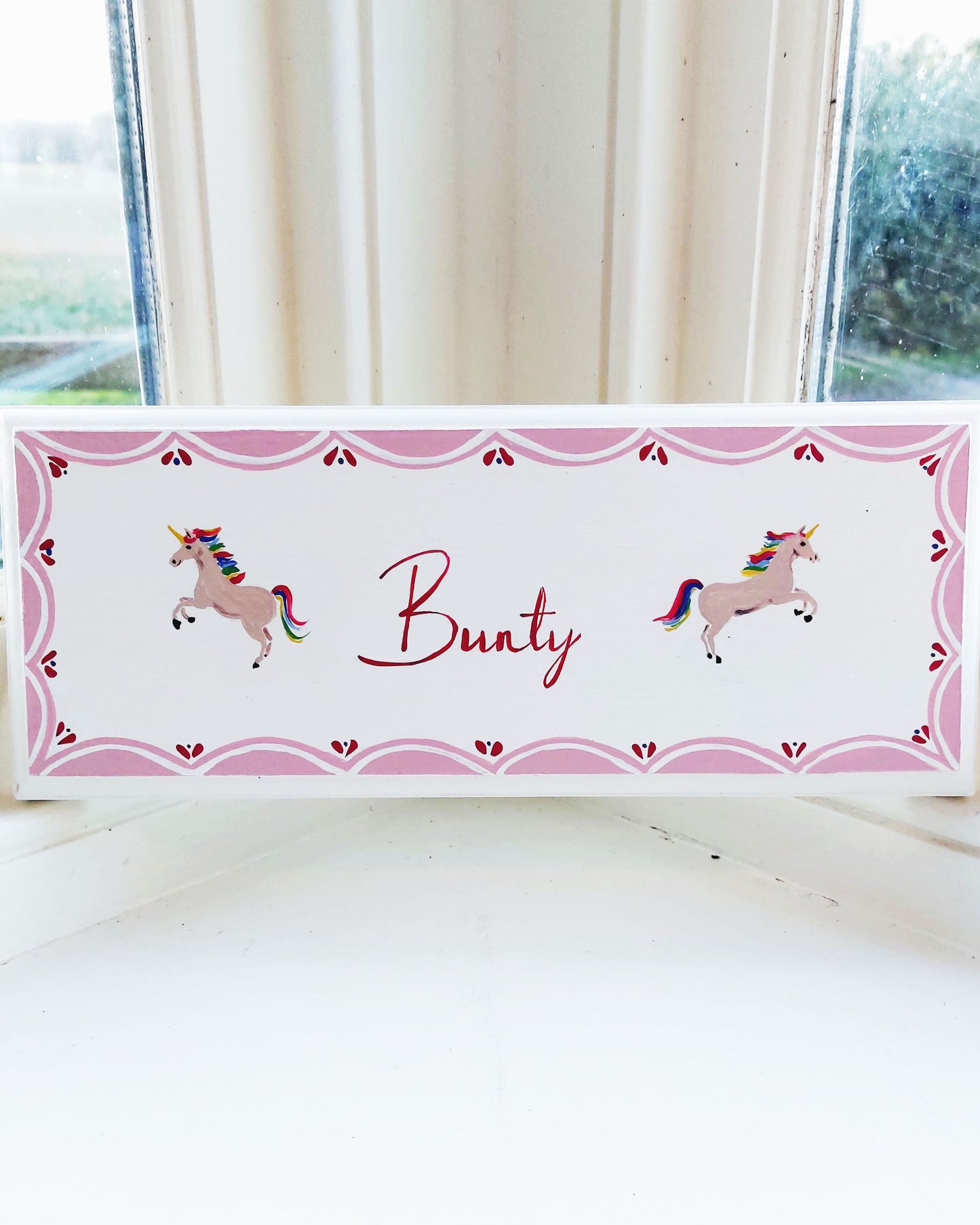 Nursery door sign personalised with the name 'Bunty', featuring magical rainbow-maned unicorns and a decorative pink scalloped border, perfect for baby room decor.