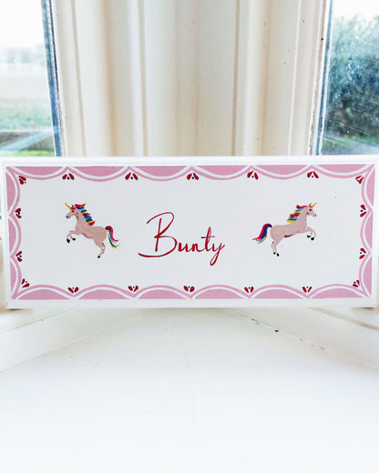 Nursery door sign personalised with the name 'Bunty', featuring magical rainbow-maned unicorns and a decorative pink scalloped border, perfect for baby room decor.