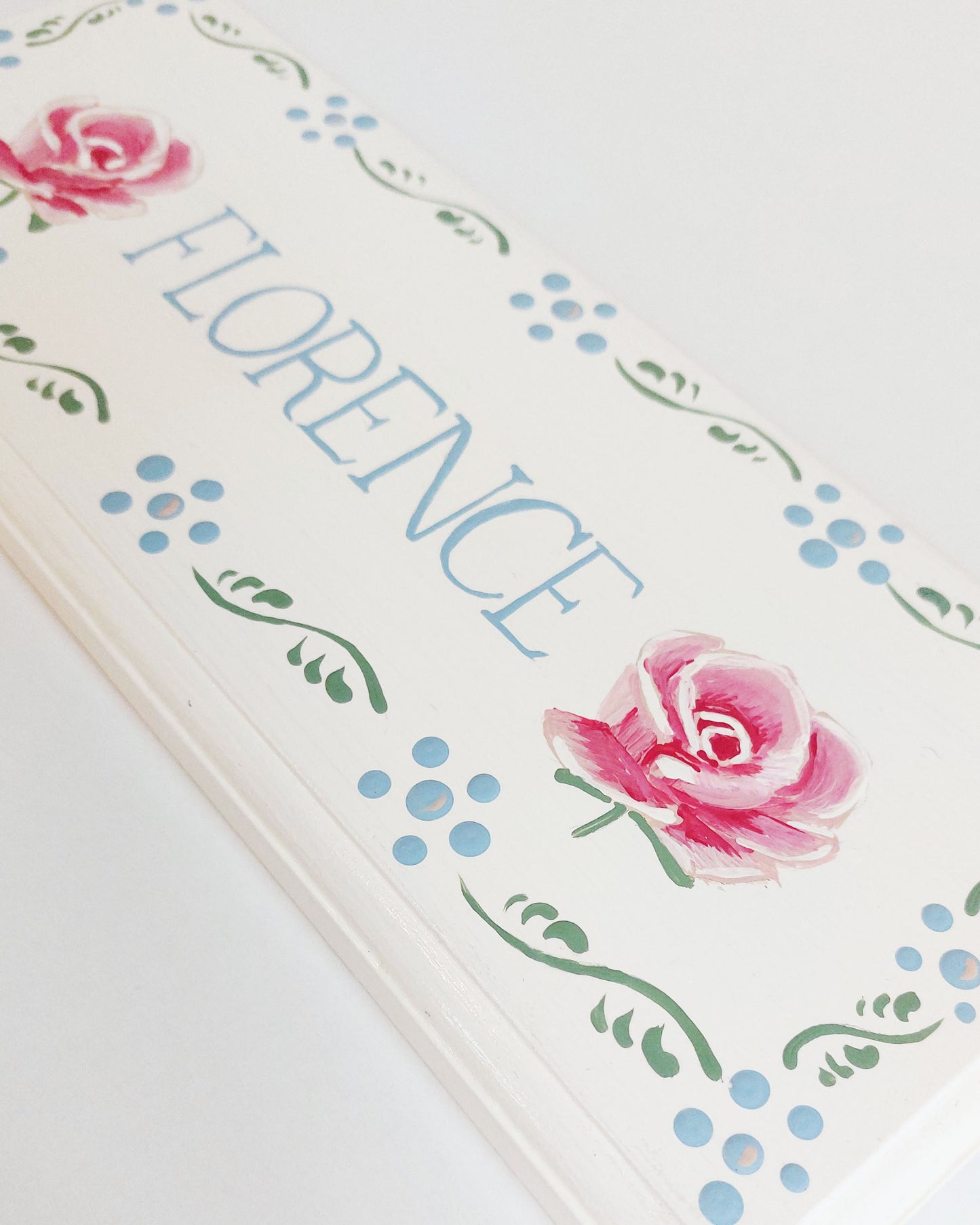 Nursery door sign personalised with the name 'Florence', featuring beautiful roses and a decorative blue floral border, perfect for baby room decor.