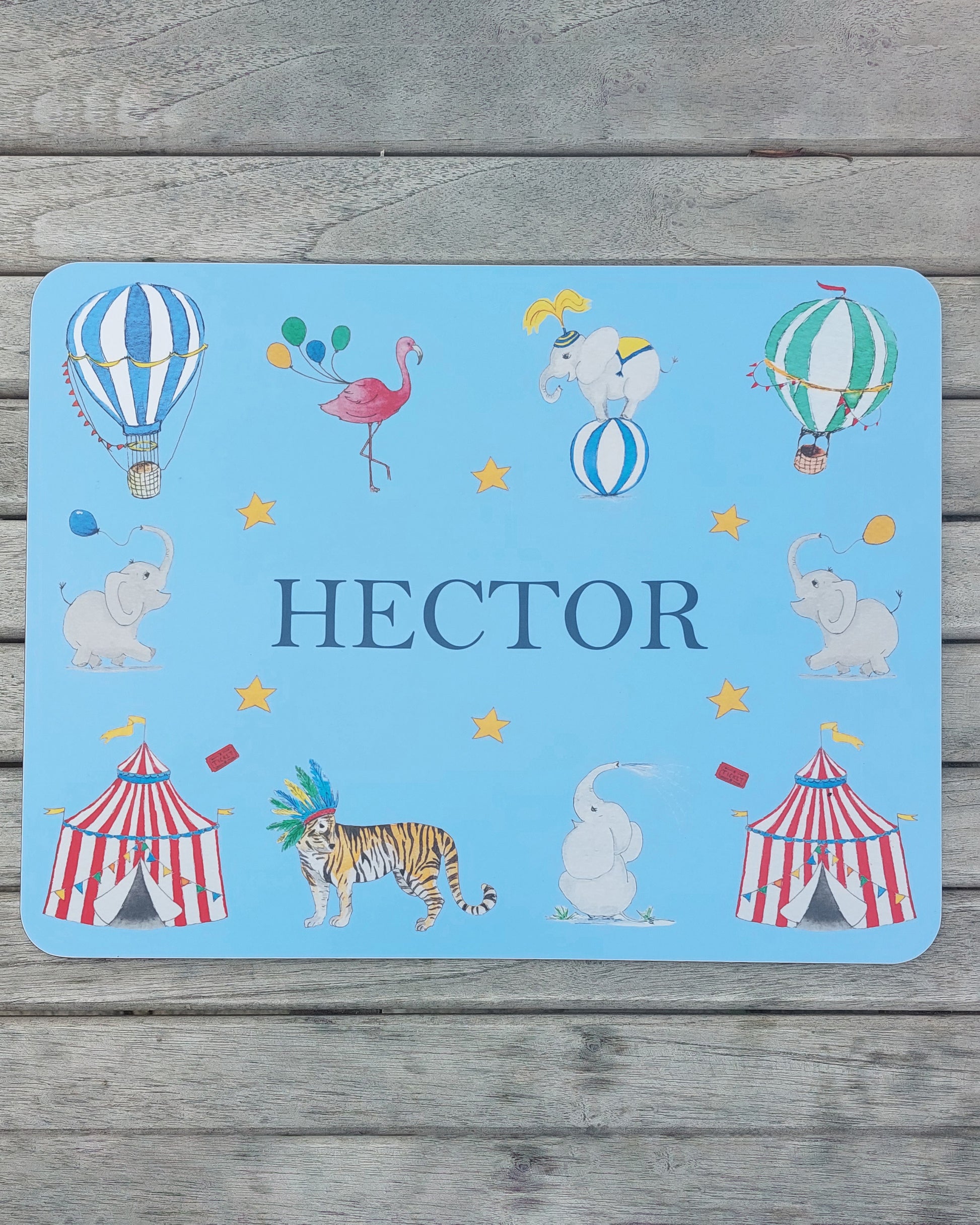 Hand-painted watercolour melamine placemat featuring various circus animals and tents, cork-backed and heat-resistant, ideal for kids' meals, made in the UK.