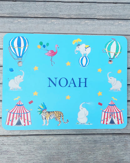 Hand-painted watercolour melamine placemat featuring various circus animals and tents, cork-backed and heat-resistant, ideal for kids' meals, made in the UK.