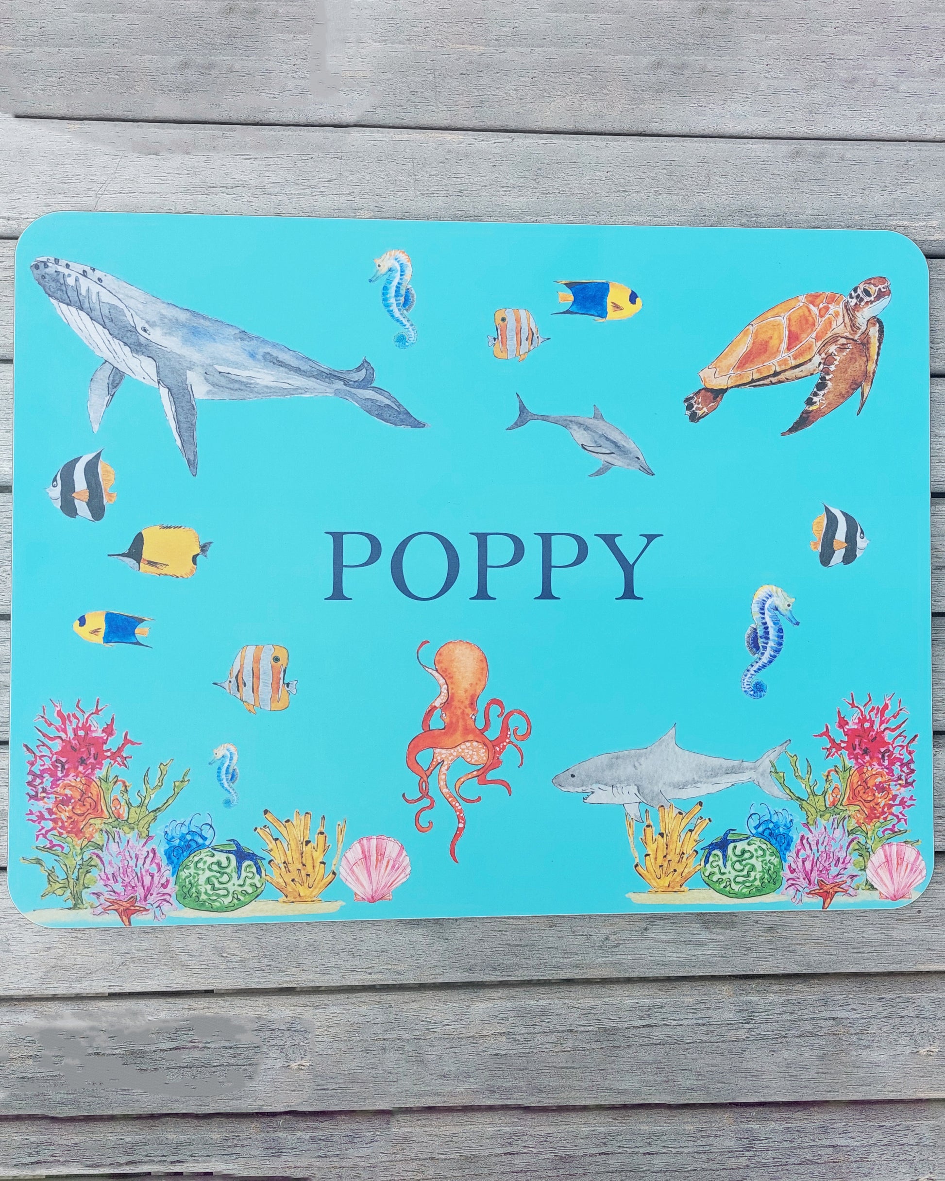 Hand-painted watercolour melamine placemat featuring various sea creatures, cork-backed and heat-resistant, ideal for kids' meals, made in the UK.