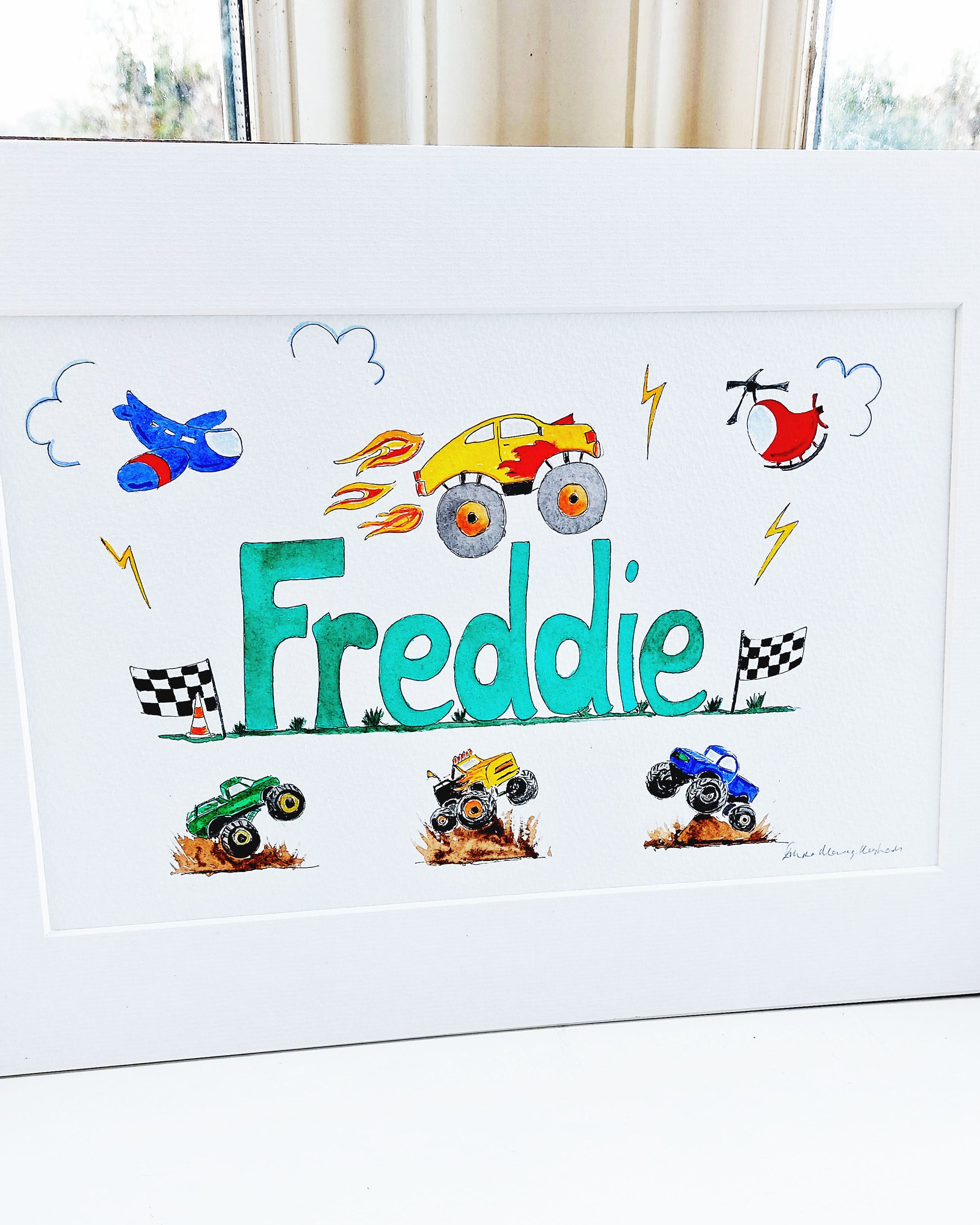 Hand-painted watercolour name painting for nursery decor, featuring the name 'Freddie', personalised with a monster trucks theme, perfect for children's room wall art.