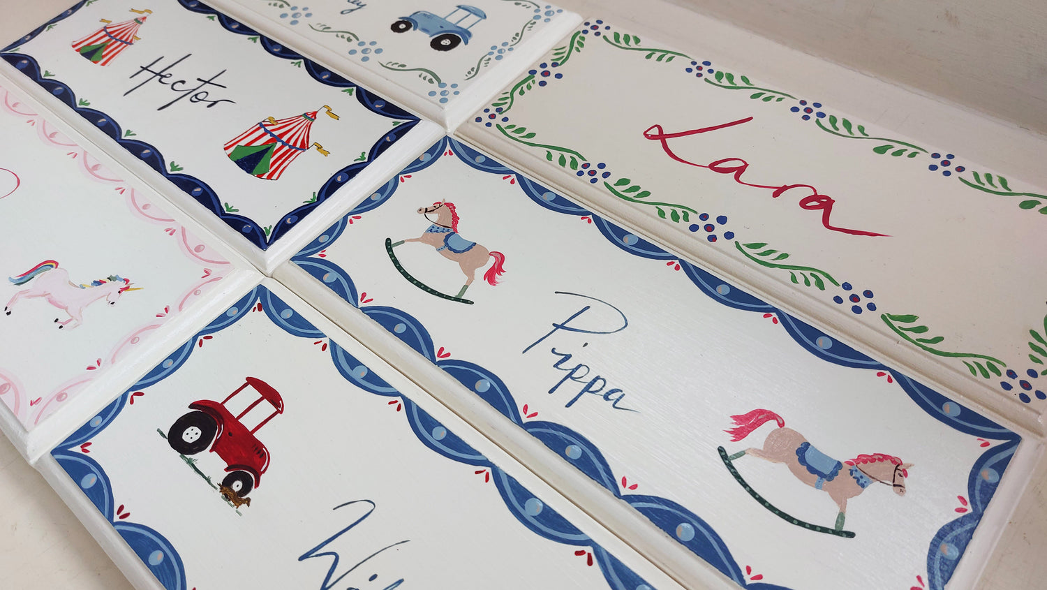 A collection of hand-painted nursery door signs features unique names and designs. 